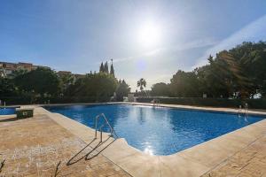ein großer Pool mit Sonne im Hintergrund in der Unterkunft Cozy Flat Simona Costa del Sol in Benalmádena