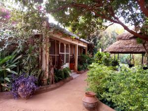 a house with a porch and a thatch roof at Villa Bobo in Bobo-Dioulasso