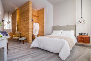 a bedroom with a large white bed and a table at Room 55 in Noto