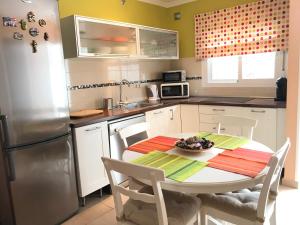 eine Küche mit einem Tisch und einem Kühlschrank in der Unterkunft Apartamento Holiday on the Beach in Torremolinos
