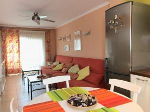 ein Wohnzimmer mit einem roten Sofa und einer Küche in der Unterkunft Apartamento Holiday on the Beach in Torremolinos