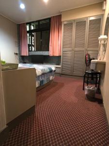 um quarto com uma cama, uma secretária e uma cadeira em Ya Shi Deng Hotel em Jiaoxi