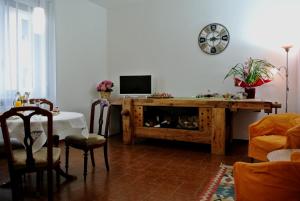 un soggiorno con TV e tavolo con sedie di B&B LORI a Como