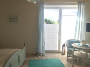 a bedroom with a bed and a table and a window at Meeresbrise in Laboe
