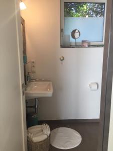 La salle de bains blanche est pourvue d'un lavabo et d'un miroir. dans l'établissement Meeresbrise, à Laboe
