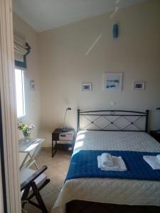 1 dormitorio con 1 cama con manta azul y blanca en Elen House, en Chiliadou