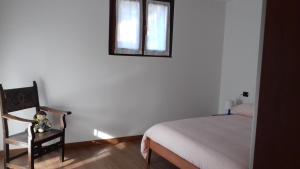 a bedroom with a bed and a chair and a mirror at Casa Matilde in Vercana