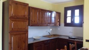 a kitchen with wooden cabinets and a sink and a window at Casa Matilde in Vercana