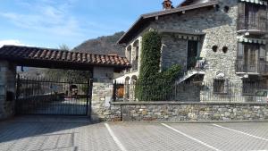 a stone building with a gate and a fence at Casa Matilde in Vercana