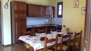 a kitchen with a table with chairs and a tableclotholitics at Casa Matilde in Vercana +18 photos
