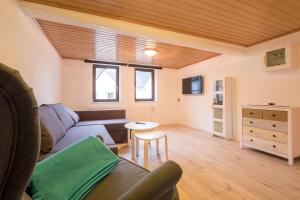 un soggiorno con un divano e un tavolo di Haus Innerdorf gemütliches Ferienhaus im Taunus a Pohl