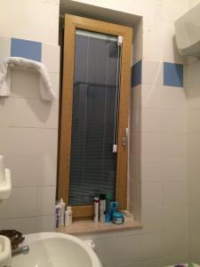 a bathroom with a sink and a toilet and a window at Residence Ducale in Rodi Garganico