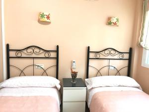 2 nebeneinander sitzende Betten in einem Schlafzimmer in der Unterkunft Apartamento Holiday on the Beach in Torremolinos