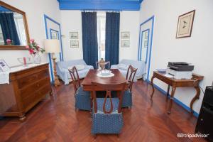 a living room with a table and a desk at Olympia Hotel in Genoa