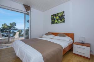 a bedroom with a large bed and a balcony at Villa Dalmatia Apartments in Brela
