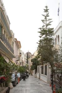 a tree on the side of a street with cars at Artemis Apartment @ Plaka in Athens