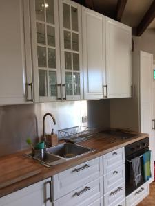 a kitchen with white cabinets and a sink at The Salt House in Avoise