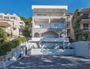 ein weißes Gebäude mit einer Treppe davor in der Unterkunft Villa Dalmatia Apartments in Brela