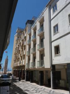 a large white building with a car parked next to it at Casa Picadeiro in Figueira da Foz
