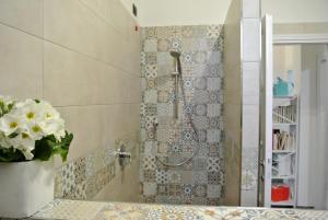 e bagno con doccia e parete a mosaico. di B&B LORI a Como