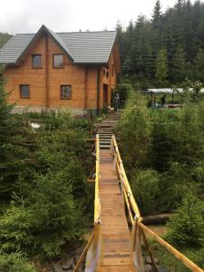 a wooden walkway leading to a log cabin at WoodDream in Volovets