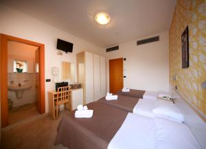 a hotel room with two beds and a bathroom at Hotel Petrarca in Rimini