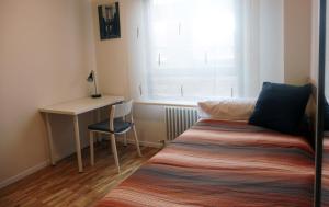 een bed in een kamer met een bureau en een raam bij Ático en Pamplona in Barañáin