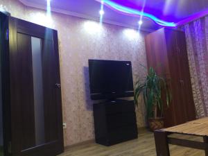 a room with a tv on a dresser and a door at Apartment on Chkalova in Maykop