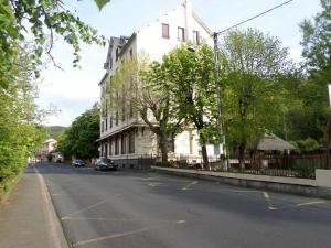 a street with a white building on the side of the road at Ptit Savoy in Saint-Nectaire