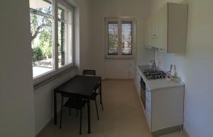 - une cuisine avec une table, une cuisinière et un comptoir dans l'établissement Dimora salentina, à Uggiano la Chiesa