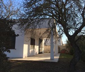 une maison blanche avec un arbre en face dans l'établissement Dimora salentina, à Uggiano la Chiesa