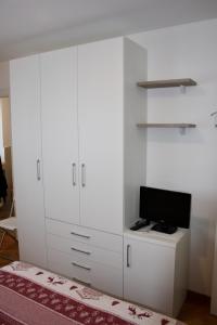 un armadietto bianco con una TV sopra di Appartamento Alla Fonte a Madesimo