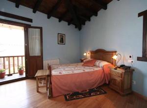 a bedroom with a large bed and a large window at Hotel O Forno in Salcedo