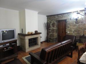 - un salon avec un canapé et une télévision dans l'établissement Refúgio da Geira, à Campo do Gerês