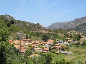 a village in a valley with mountains in the background at Refúgio da Geira in Campo do Gerês