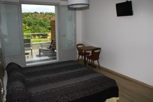 a bedroom with a bed and a balcony with a table at L'Attrachju in Corte