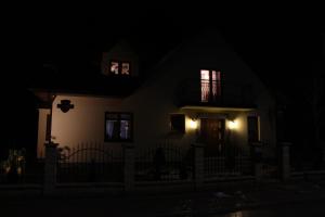 una casa por la noche con las luces encendidas en Pokoje Gościnne Сisza, en Białowieża