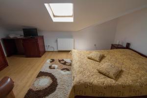 a bedroom with a bed with a window and a rug at Pensiunea Casa Anca in Agapia