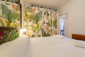 a bedroom with a large white bed with floral wallpaper at Central Almuñecar, Beach Playa 125 metres, by Old Town in Almuñécar +33 photos