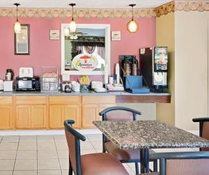 a kitchen with a counter and a table with chairs at Super 8 by Wyndham Kosciusko in Kosciusko