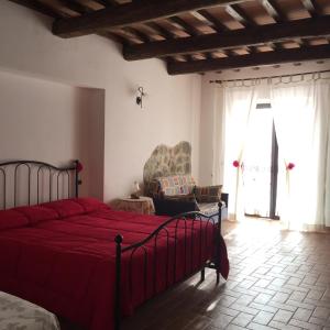 a bedroom with a red bed and a chair at Poggio Moretto in Manciano