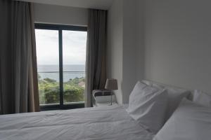 a bedroom with a bed and a large window at Hospedagem Portal dos Vimes AL in São João