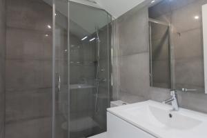 a bathroom with a glass shower and a sink at Hospedagem Portal dos Vimes AL in São João
