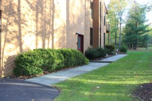 a house with a sidewalk next to a building at Attractive East Hill Apartment in Ithaca