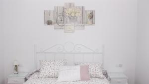 - une chambre blanche avec un lit et un oreiller rose dans l'établissement El Capricho de San Fernando, Consigna gratis y Parking a 200mts, à Cordoue