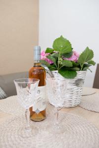 Revolution Apartment في تيميشوارا: زجاجة من النبيذ وكأسين من النبيذ على الطاولة