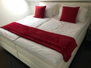 Una gran cama blanca con almohadas rojas. en Luxus-Appartement im Herzen der Stadt, en Bad Kreuznach