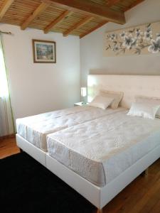 a bedroom with a large white bed in a room at Casa do campo do forno in Amorosa