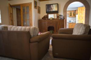 a living room with two chairs and a fireplace at Casa Rural La Fueya in Oviñana