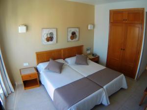 a bedroom with a large white bed with two pillows at Hotel Albatros in Gandía